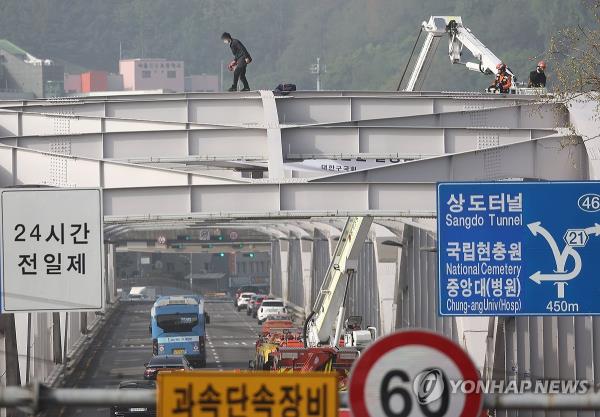 An unidentified man walks on top of the Han River Bridge on April 17, 2024, causing severe gridlock after police and firefighter officials deployed perso<em></em>nnel to rescue the man. (Yonhap)